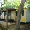Casa mobile con veranda in legno tra gli alberi.