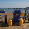 Sedie a rotelle da spiaggia sulla sabbia vicino al mare.