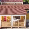 Bungalow giallo con tetto rosso.