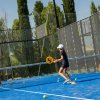 Due persone giocano a padel su un campo blu.