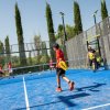 Ragazzi giocano a padel su un campo all'aperto.