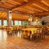 Ristorante spazioso con travi in legno e tavoli gialli.