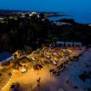 Veduta aerea di un'area spiaggia illuminata di notte, con ombrelloni.