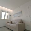 Sala con divano beige e finestra.