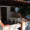Veranda con tavolo e sedie bianche all'aperto.