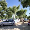 Un campeggio con auto parcheggiate e persone che camminano.