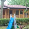 Scivolo blu in un giardino vicino a una casetta di legno.
