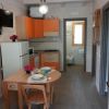 Cucina moderna con mobili arancioni e tavolo apparecchiato.