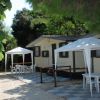 Due case prefabbricate con gazebo e tavolini all'aperto.