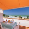 Tavolo all'aperto con vista sul mare e piscina.