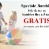 Bambini giocano sulla spiaggia con un pallone.