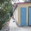 Edificio con porte blu, camminamento e fiori rosa.