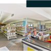 Interno di un minimarket con scaffali e cassa.