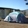 Tenda grigia e blu davanti a un edificio con tetto a capanna.
