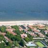Veduta aerea di una spiaggia con stabilimenti balneari, strutture turistiche e campi da gioco.