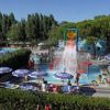 Parco acquatico con piscina, ombrelloni e giochi d’acqua.