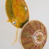Due scudi decorativi rotondi con motivi geometrici gialli e rossi.