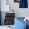 Valigie vintage accanto a un letto su pavimento in legno chiaro.