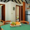 Cucina moderna con tavolo verde e frutta sul tavolo.
