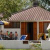 Bambini giocano nel giardino di una casetta.