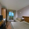 Camera con letto matrimoniale, TV e balcone vista mare.