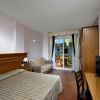 Camera con letto matrimoniale, TV e balcone vista cortile.