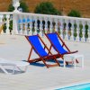 Sdraio blu e lettini bianchi a bordo piscina.