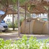 Tenda da campeggio e camper sotto una pergola.