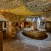Antica sala sotterranea con macina in pietra.
