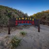 Ingresso camping con cartello su spiaggia.