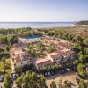 Vista aerea di un resort con piscina vicino al mare.