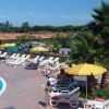 Piscina con lettini e ombrelloni gialli.