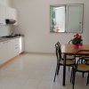 Cucina con tavolo da pranzo e sedie, finestra aperta.