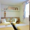 Camera doppia con letti singoli, tenda e peluche sul letto.
