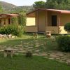 Due bungalow in un giardino con aree verdi e sentieri di pietra.