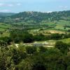Colline verdi e campi con cielo sereno in lontananza.