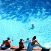 Piscina rotonda con bagnanti e scivolo.