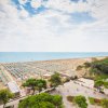 Spiaggia affollata vista dall'alto con mare e cielo.