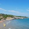 Spiaggia con pedalò gialli e mare blu limpido.