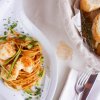 Piatto di pasta con gamberi e pane.