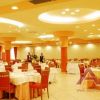 Una sala ristorante elegante con tavoli apparecchiati e sedie rosse.