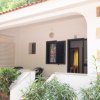 Veranda di una casa bianca con piante e sedie.