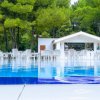 Bar con tavoli bianchi vicino a una piscina.