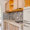 Cucina con piastrelle decorative e frigo retrò.