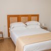 Camera con letto matrimoniale e comodini, arredata in toni bianchi e beige.