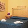 Una camera da letto con letto matrimoniale, copriletto blu e mobili in legno.