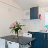 Cucina moderna con tavolo blu e sedie bianche.