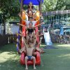 Bambini scivolano insieme giù per uno scivolo rosso.