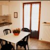 Cucina con tavolo bianco e sedie nere.