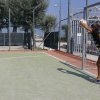 Ragazzo para un pallone su un campo sportivo.